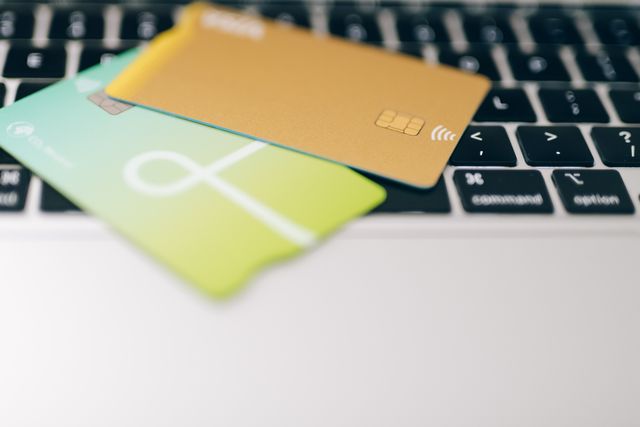 two credit cards sitting on a laptop